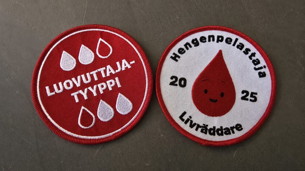 Kaksi ensimmäisellä verenluovutuskerralla saatua kangasmerkkiä.